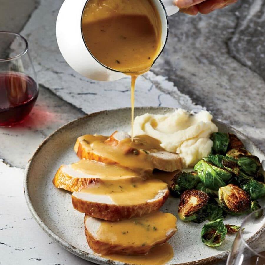 thanksgiving turkey dish with gravy being poured