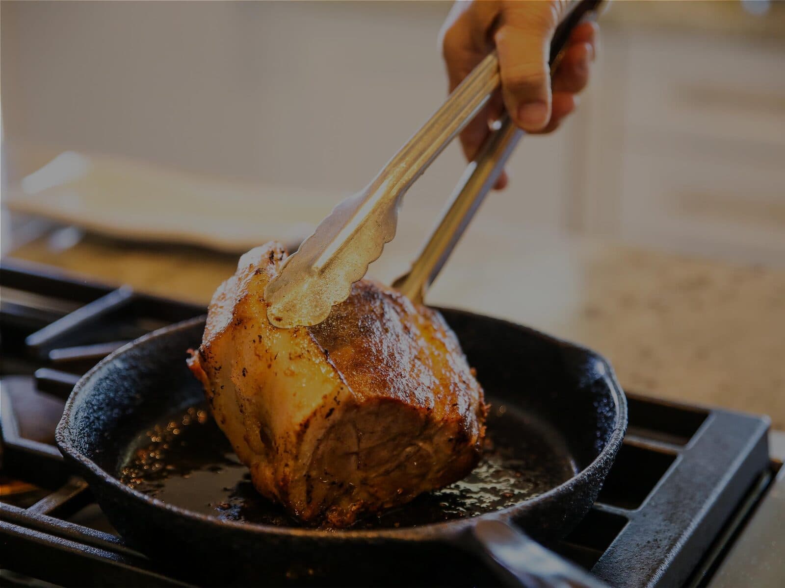 Grass-fed beef searing in a cast-iron pan